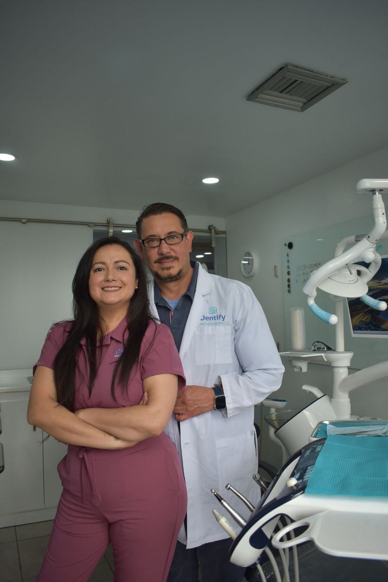 Imagem ilustrativa de banco: dois profissionais de odontologia em pé, sorrindo, dentro de um consultório